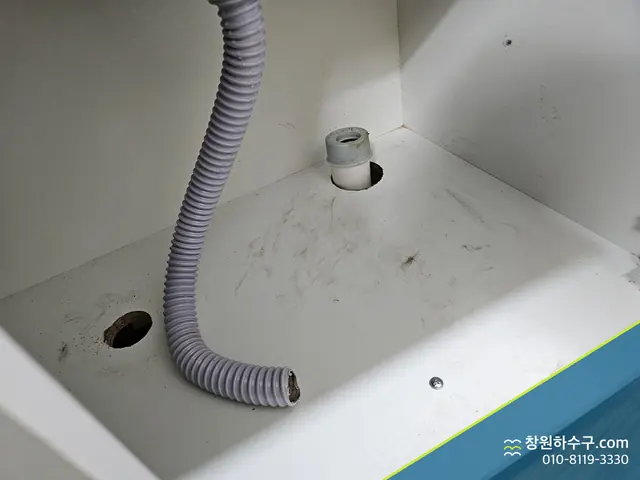 싱크대 하부장 바닥으로 이어진 배수 주름관