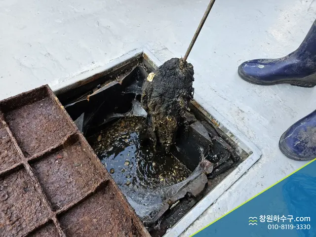 그리스트랩에서 기름 찌꺼기를 퍼내는 중